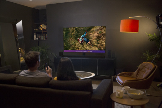 LG전자 모델이 'LG 시그니처 올레드 TV W'를 시청하고 있다. <LG전자 제공>